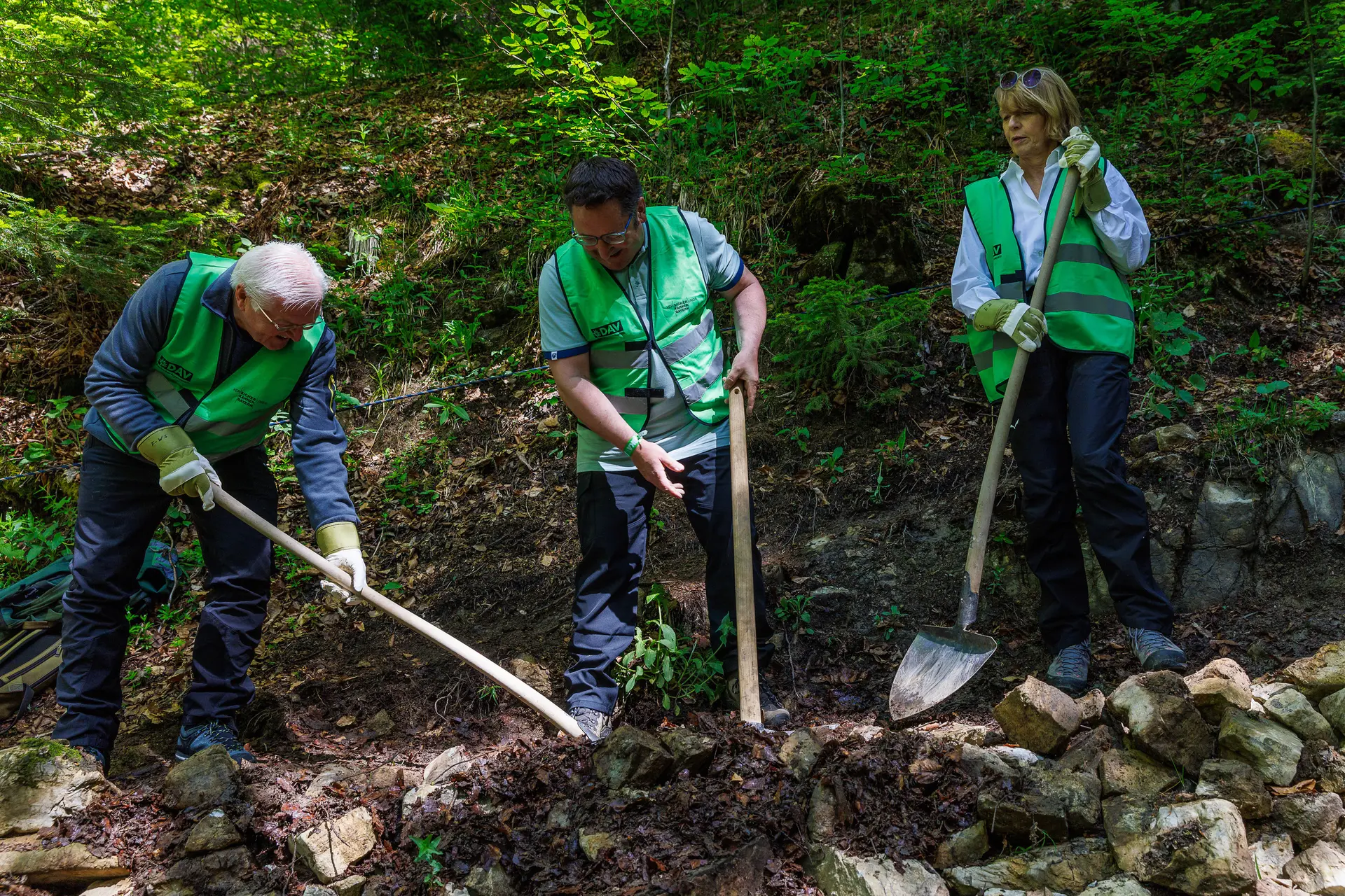 Bundespräsident mit Ehefrau beim Wegebau | © Bundespräsident Frank-Walter Steinmeier und seine Frau Elke Büdenbender werden von Staatssekretär Tobias Gotthardt (Mitte) bei der Wegepflege unterstützt. Foto: DAV/Marco Kost