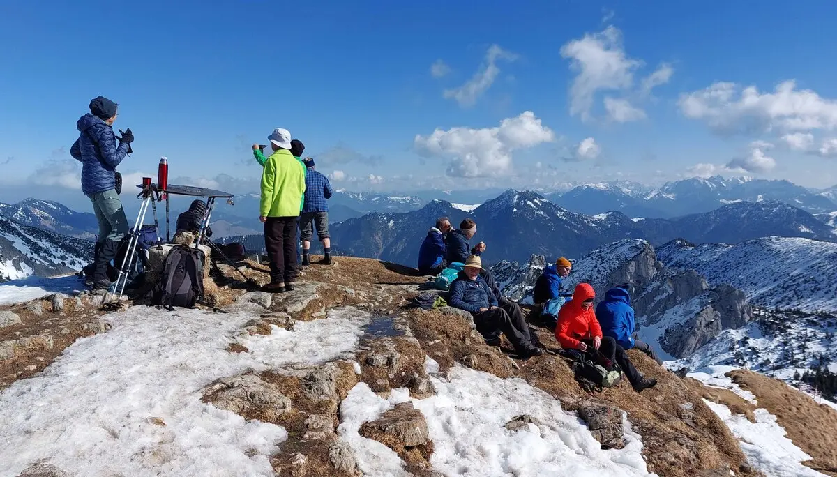 © Rotwand 1884 m  DiMiDo am 04.03.2026  Unsere Winterwanderung auf die Rotwand (800 Höhenmeter) haben wir von dem bekannten Kirchen-Parkplatz am Spitzingsee gestartet. Der Weg war bis zur Bergwachthütte und auch weiter schneefrei, später etwas schneebedeckt oder vereist. Erst kurz vor der Wildfeld-Alm hat die Landschaft wieder an Winter erinnert. Und nach der Wildfeld-Alm war Schnee in rauen Mengen vorhanden. Hier wurde der Schnee, auch aus den vorherigen Lawinen, maschinell zur Seite geschoben um den Zugang zum Rotwandhaus auf bequeme Weise zu ermöglichen. Nach einer kurzen Gipfelpause sind wir zum Rotwandhaus abgestiegen und das traumhafte Wetter auf der Hüttenterrasse, mit dem Blick auf die Ruchenköpfe, genossen.  TL: Peter J. TN: 14 Bilder: Wolfgang  Text: Peter J.