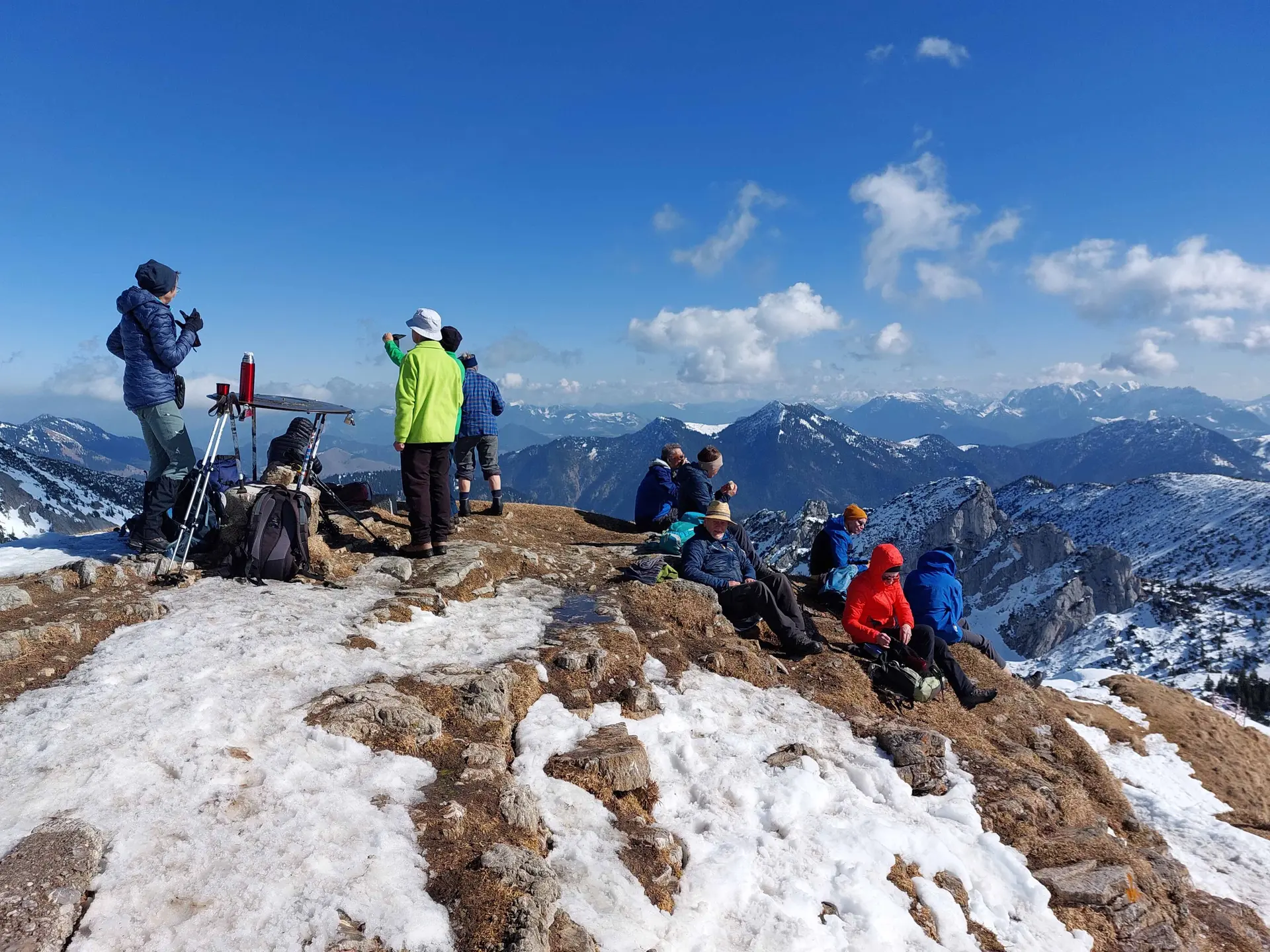 © Rotwand 1884 m  DiMiDo am 04.03.2026  Unsere Winterwanderung auf die Rotwand (800 Höhenmeter) haben wir von dem bekannten Kirchen-Parkplatz am Spitzingsee gestartet. Der Weg war bis zur Bergwachthütte und auch weiter schneefrei, später etwas schneebedeckt oder vereist. Erst kurz vor der Wildfeld-Alm hat die Landschaft wieder an Winter erinnert. Und nach der Wildfeld-Alm war Schnee in rauen Mengen vorhanden. Hier wurde der Schnee, auch aus den vorherigen Lawinen, maschinell zur Seite geschoben um den Zugang zum Rotwandhaus auf bequeme Weise zu ermöglichen. Nach einer kurzen Gipfelpause sind wir zum Rotwandhaus abgestiegen und das traumhafte Wetter auf der Hüttenterrasse, mit dem Blick auf die Ruchenköpfe, genossen.  TL: Peter J. TN: 14 Bilder: Wolfgang  Text: Peter J.